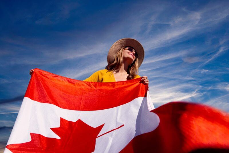 A woman holding a Canadian flag