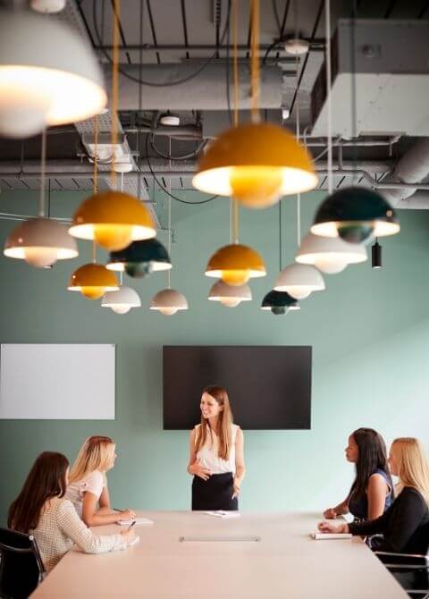 Group of Businesswomen Sitting around Boardroom Table